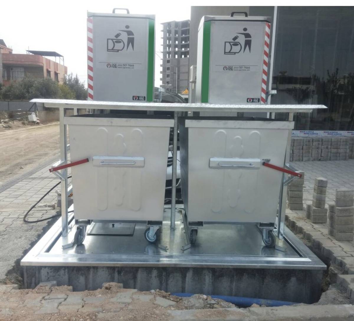 Underground dustbin lifting platform raised showing waste containers